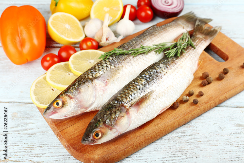 Fresh raw fish and food ingredients on table Fresh raw fish and food ingredients on table