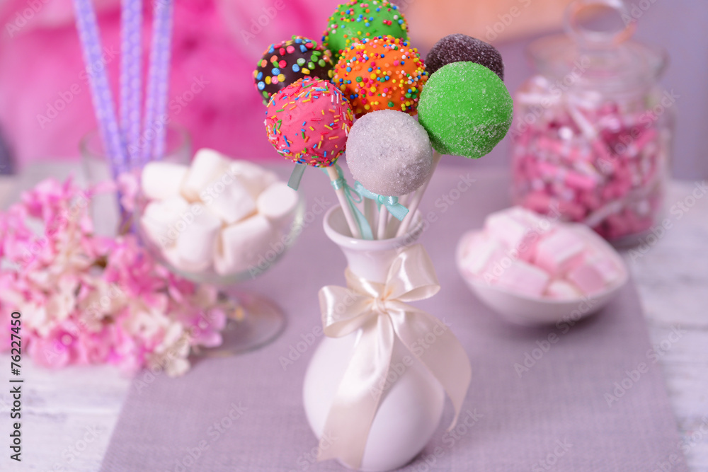 Sweet cake pops in vase on table on bright background Sweet cake pops in vase on table on bright background