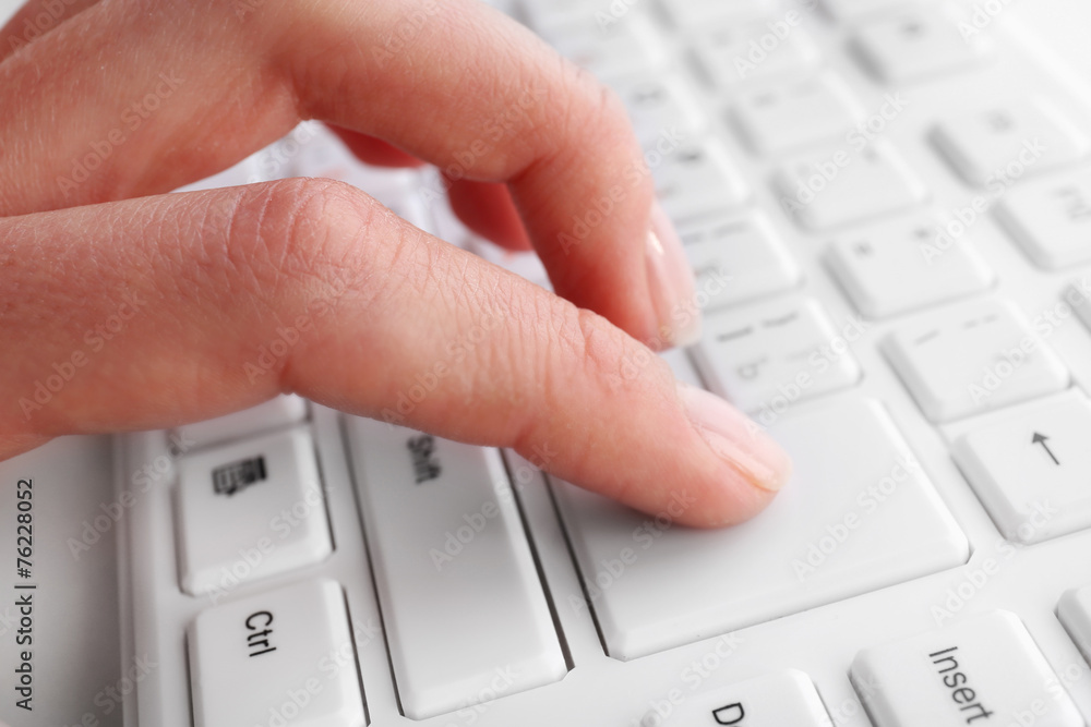 Female hand typing on keyboard, macro view Female hand typing on keyboard, macro view