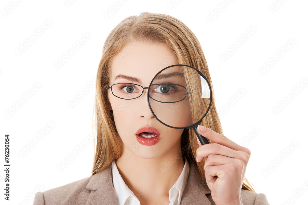 Businesswoman looking into a magnifying glass Businesswoman looking into a magnifying glass