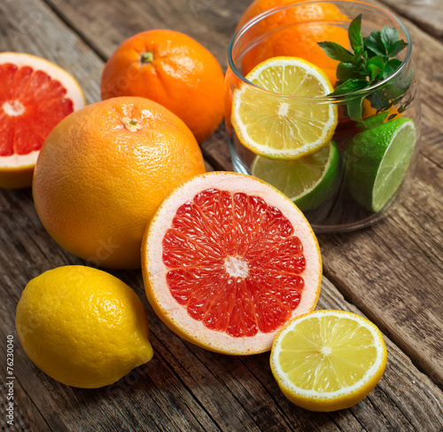 Halves of citrus fruits on wooden background. Orange  grapefruit