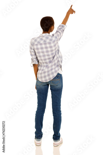 back view of young african woman pointing at empty space