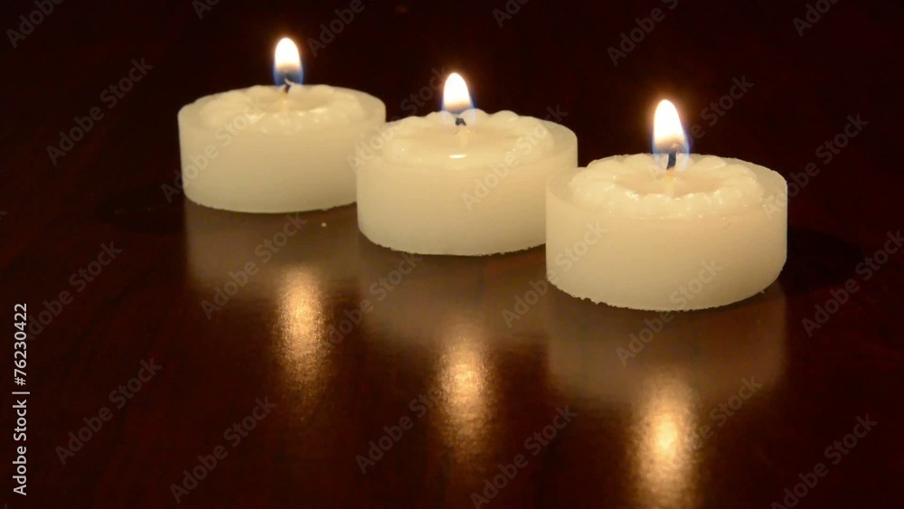 Three tea light candles burning on a table Three tea light candles burning on a table