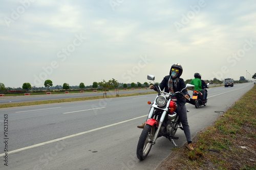 Woman riding chopper motorcycle on the way with Distance signs