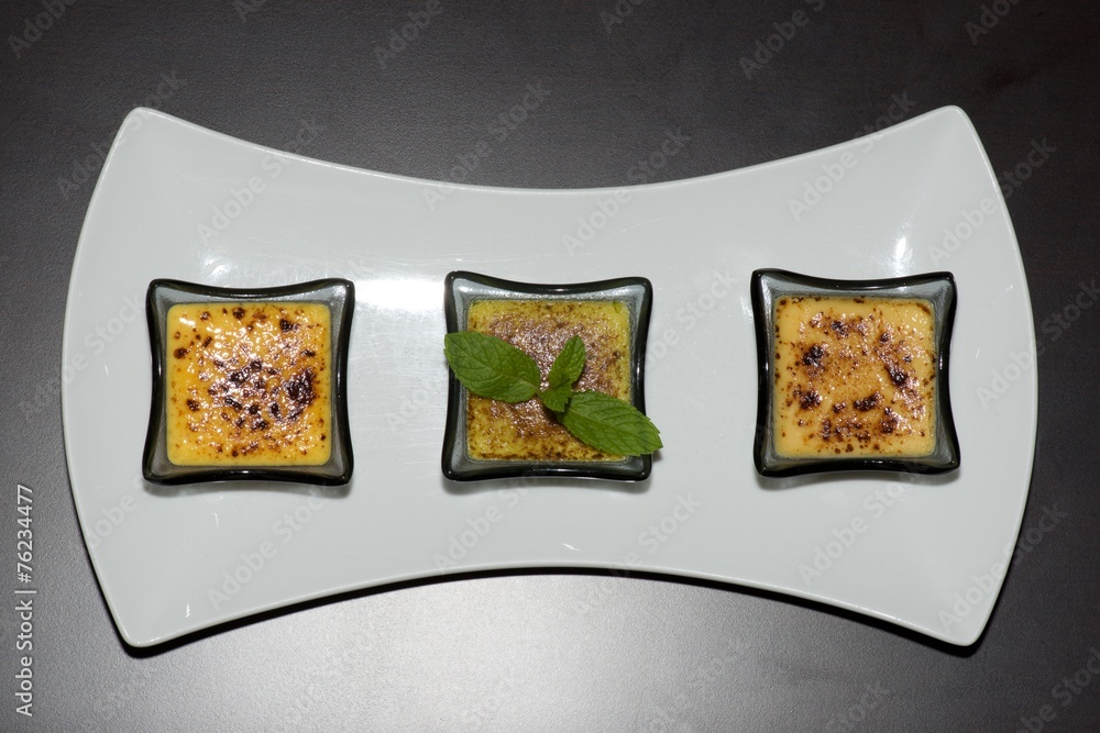 Obraz premium Plate of three creme brulees from above