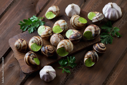 Bourguignonne snail au gratin, rustic wooden background