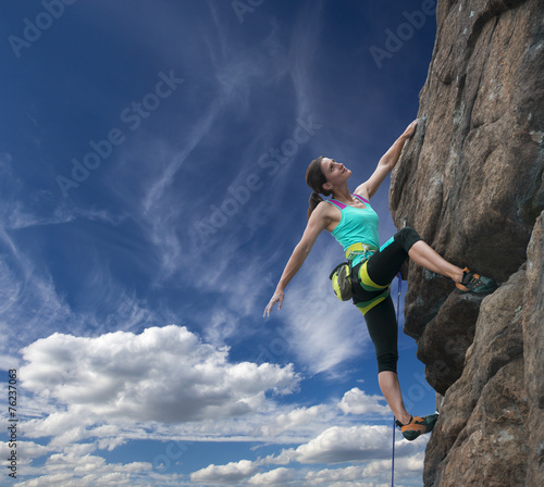 Elegant female alpine climber ascents natural rock