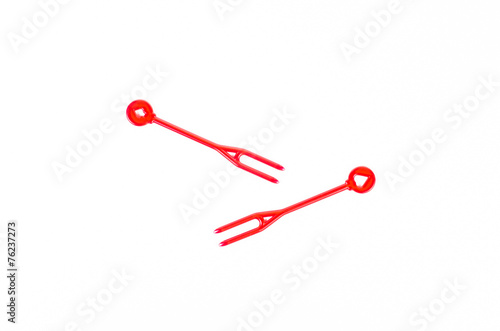 red plastic food skewer on white background