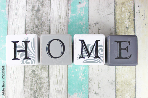 Home sign on a distressed wooden background with turquoise tones