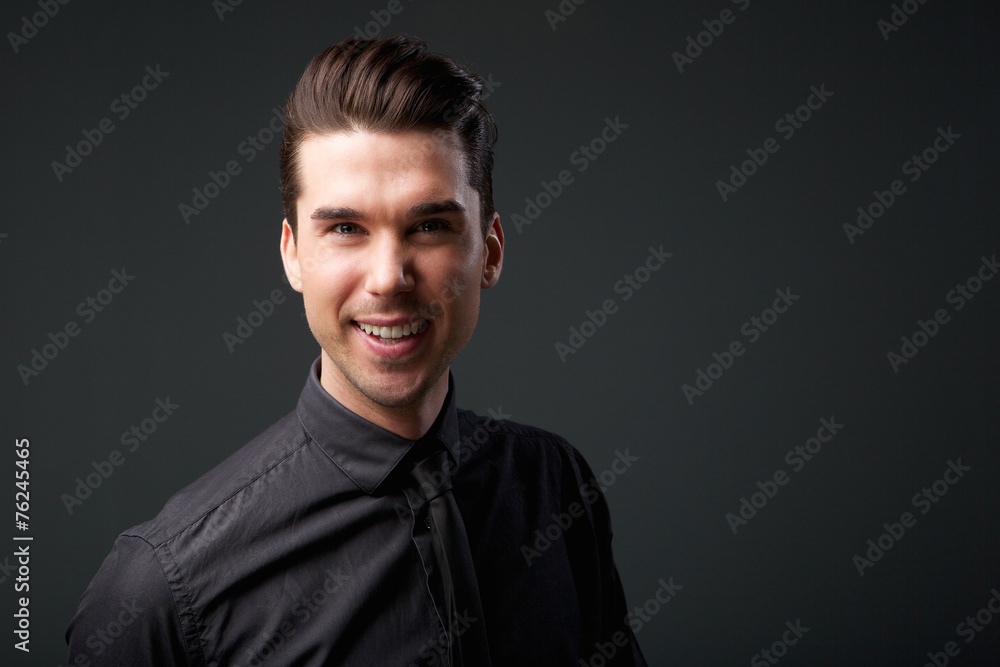 Attractive young man smiling in black shirt and tie