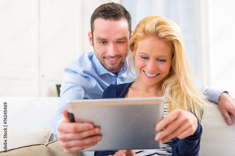 Young attractive couple having fun using tablet Young attractive couple having fun using tablet