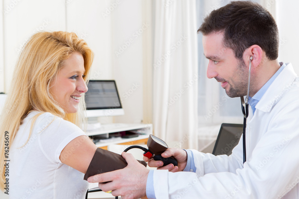 Young attractive doctor checking patient's blood pressure Young attractive doctor checking patient's blood pressure