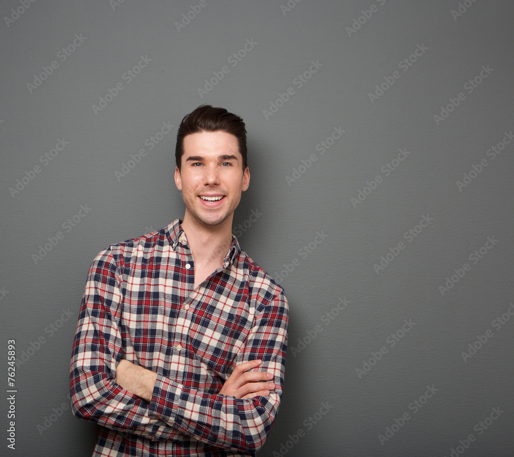 Friendly young man smiling with arms crossed Friendly young man smiling with arms crossed