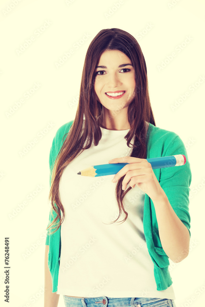 Young woman writing on copy space with pencil. Young woman writing on copy space with pencil.