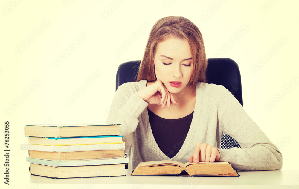 Casual student woman sitting by stack of books. Casual student woman sitting by stack of books.