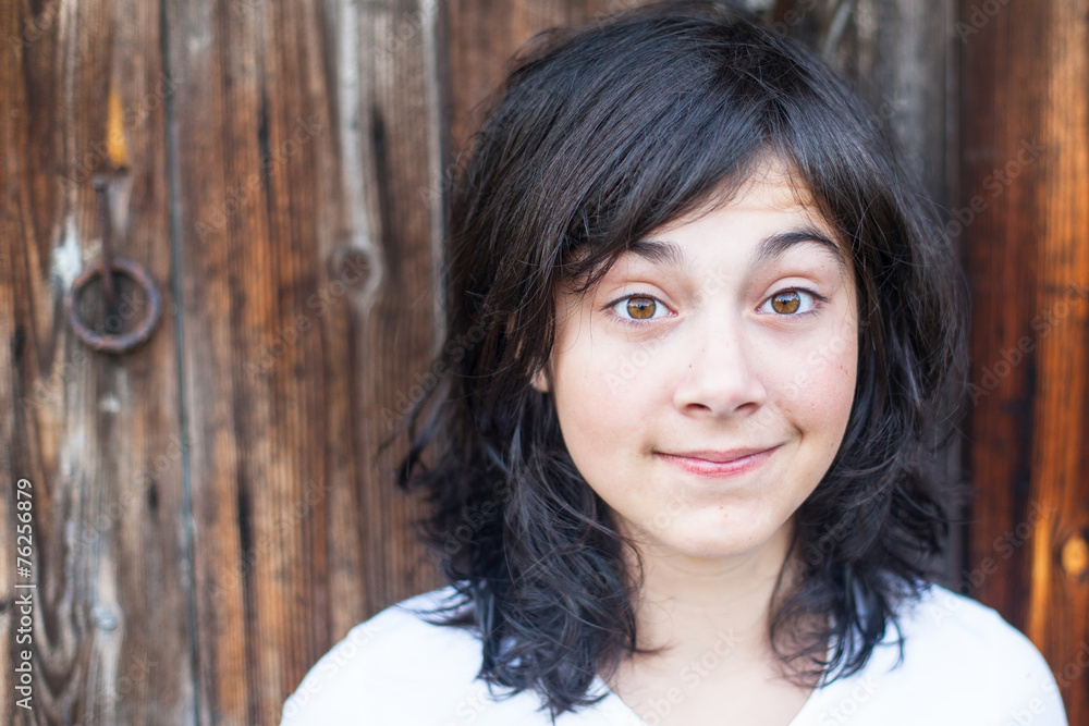Teen girl with expressive eyes portrait against a wooden wall. Teen girl with expressive eyes portrait against a wooden wall.