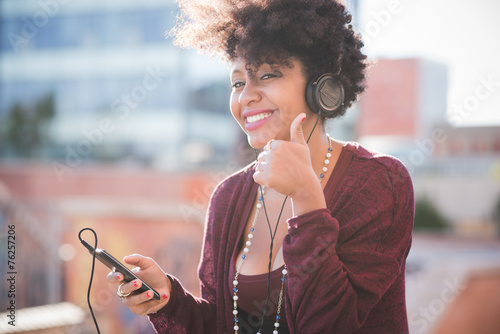 Schilderij op canvas beautiful black curly hair african woman listening music with he