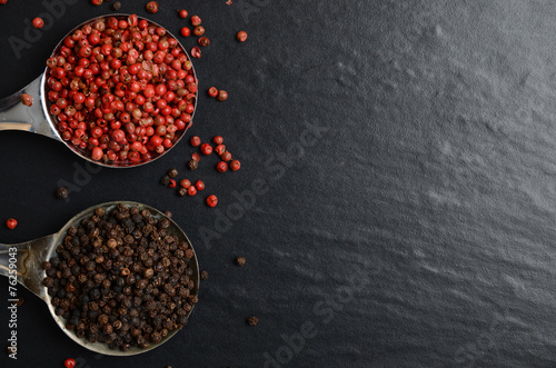 Pink and black peppercorns on a spoon