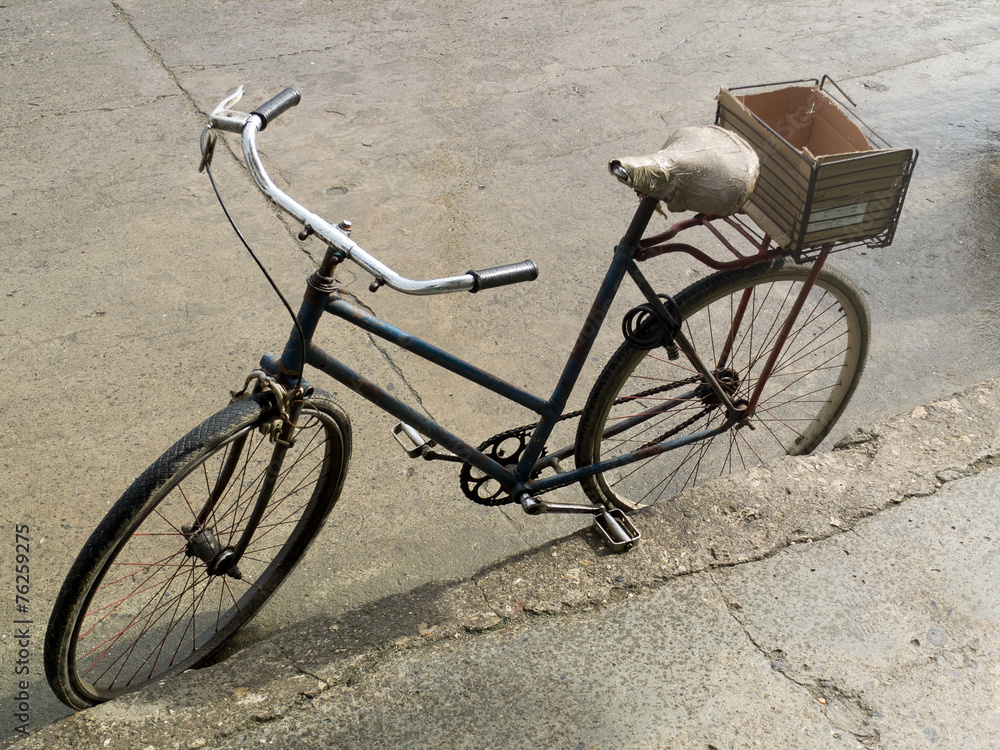 Vélo rustique garé le long d'un trottoir à Cuba.
