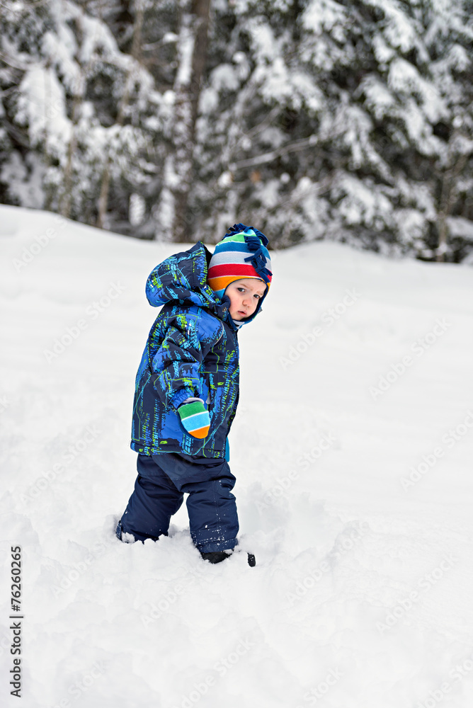 Little Boy Looking Back in a Snowy Forest