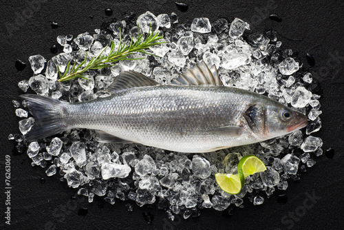 Fresh fish on ice on a black stone table top view