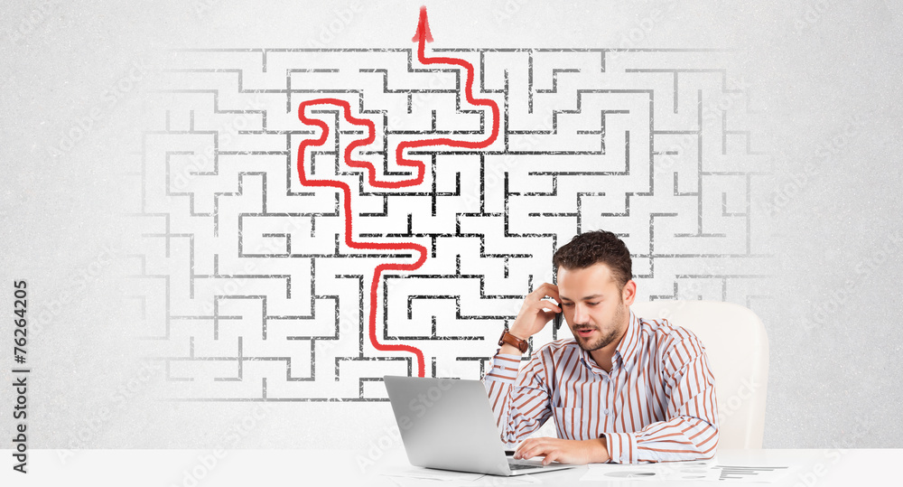 Business man at desk with labyrinth and arrow Business man at desk with labyrinth and arrow