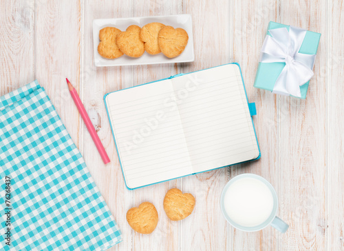 Notepad, cup of milk, heart shaped cookies and gift box