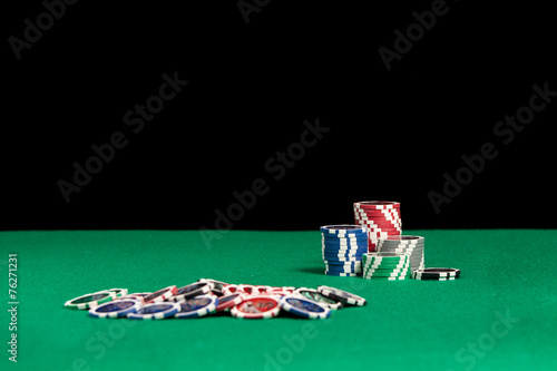 Colorful poker chips on green background with copy space