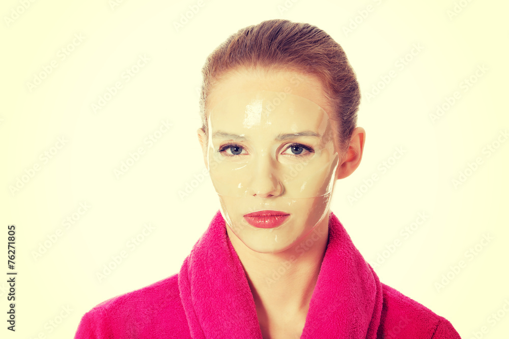 Woman in pink bathrobe having facial mask. Woman in pink bathrobe having facial mask.