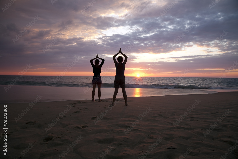 Yoga à deux au coucher du soleil