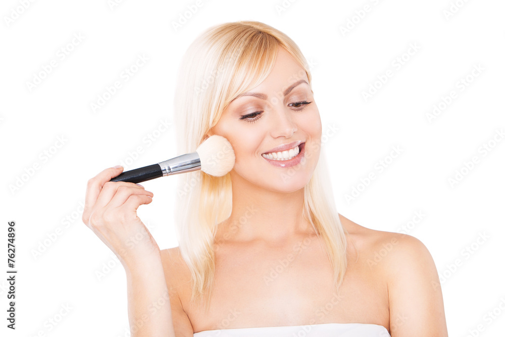 Smiling woman putting make-up on. beautiful young woman causes Smiling woman putting make-up on. beautiful young woman causes