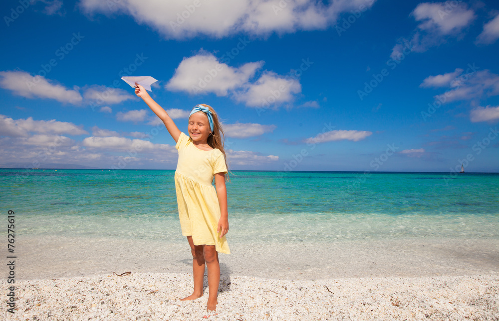 Happy little girl playing with flying kite during tropical beach Happy little girl playing with flying kite during tropical beach