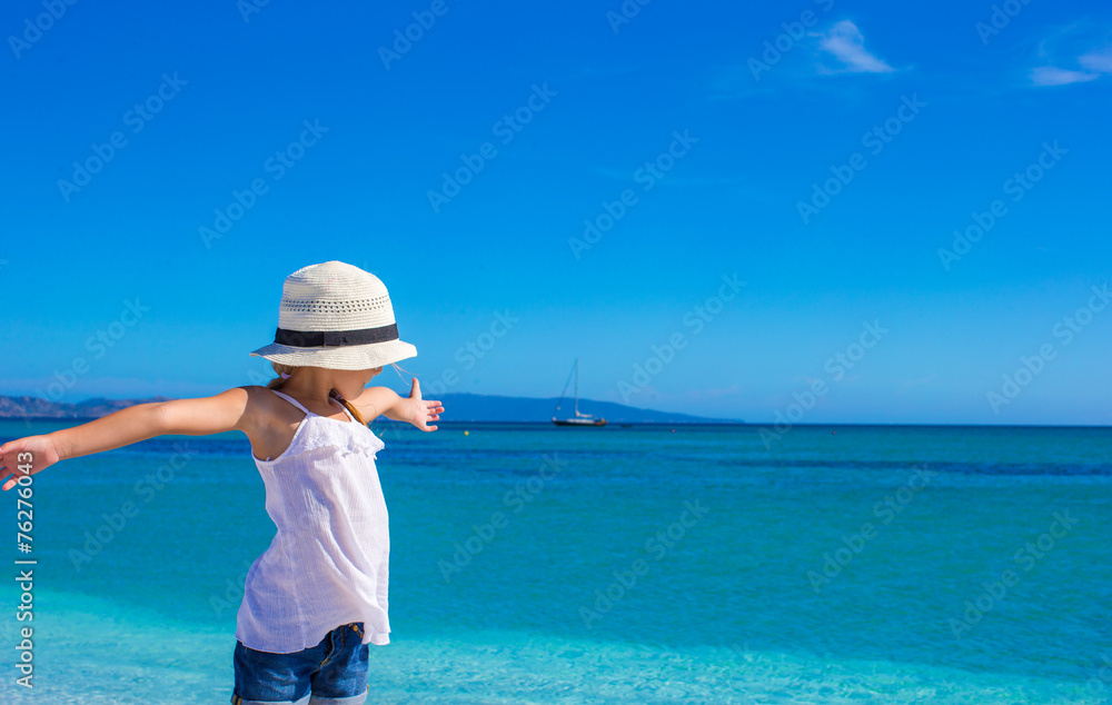 Little girl having fun on tropical beach with white sand and