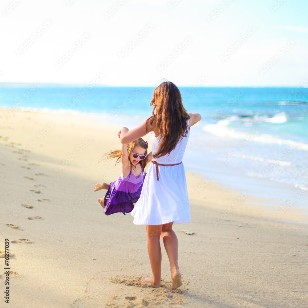 Young happy mother and adorable daughter having fun at exotic