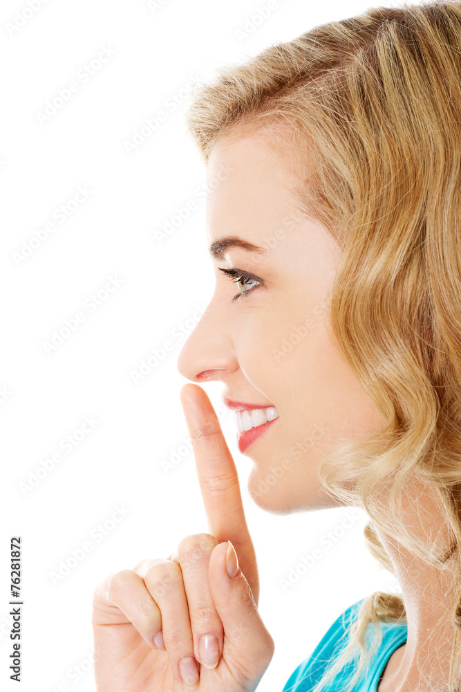 Side view of a woman making silence gesture Side view of a woman making silence gesture