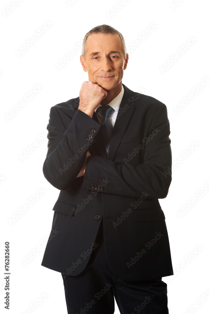 Happy mature businessman with hand under chin Happy mature businessman with hand under chin