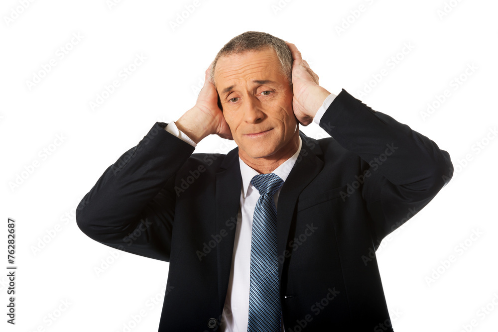 Portrait of tired man covering ears with hands Portrait of tired man covering ears with hands