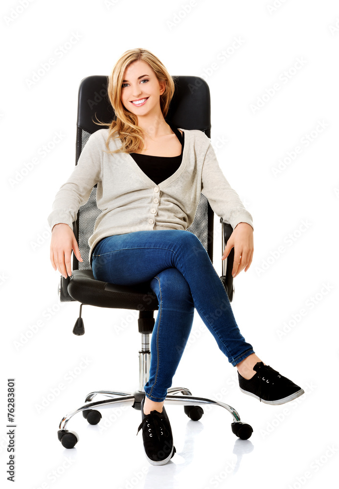 Fototapeta premium Young woman sitting on armchair