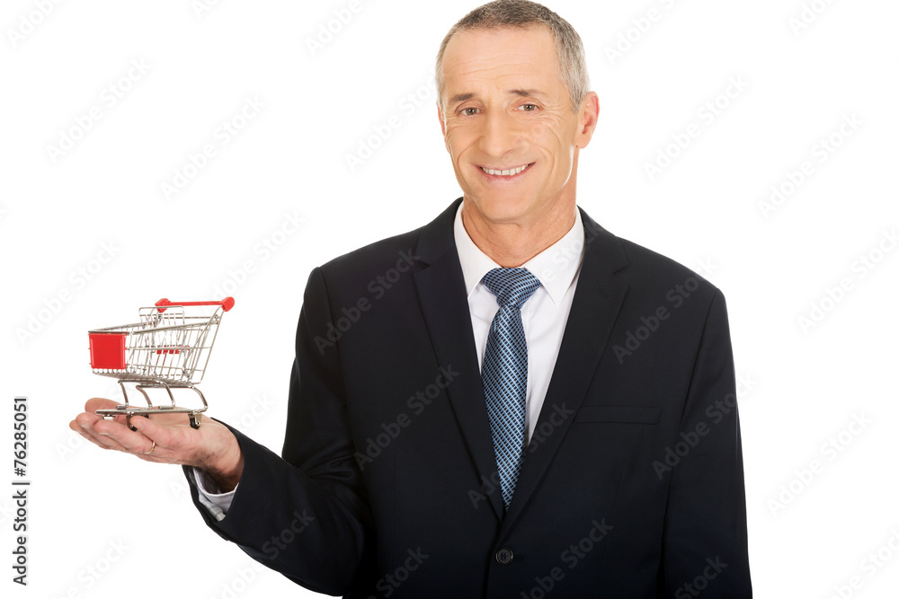 Portrait of businessman holding shopping cart Portrait of businessman holding shopping cart