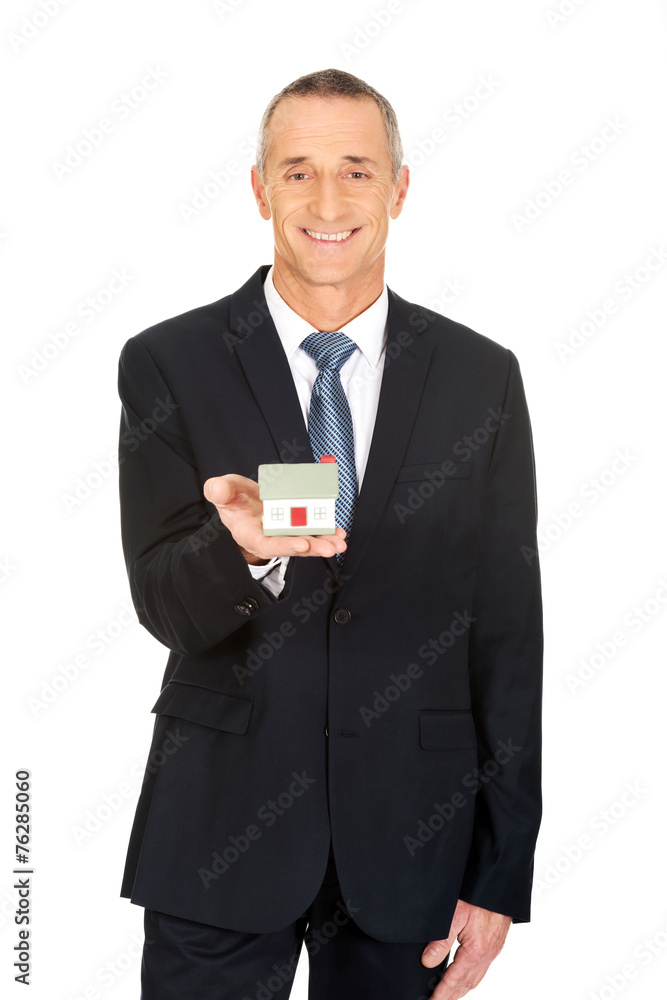 Businessman holding house model Businessman holding house model