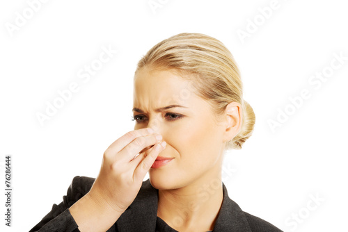 Woman pinching her nose because of disgusting smell