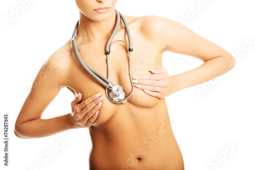 Nude woman with a stethoscope covering her breast