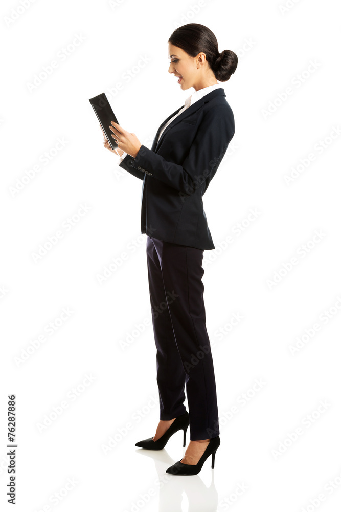 Full length happy businesswoman reading her notes Full length happy businesswoman reading her notes