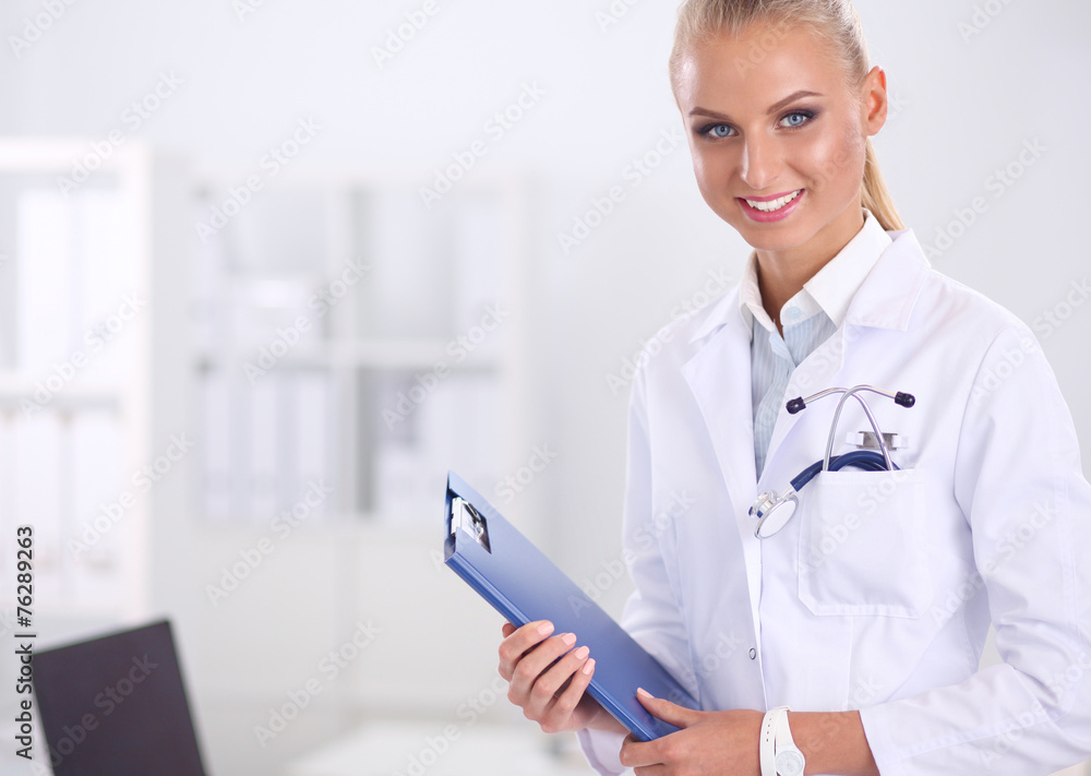 Smiling female doctor with a folder in uniform standing at Smiling female doctor with a folder in uniform standing at