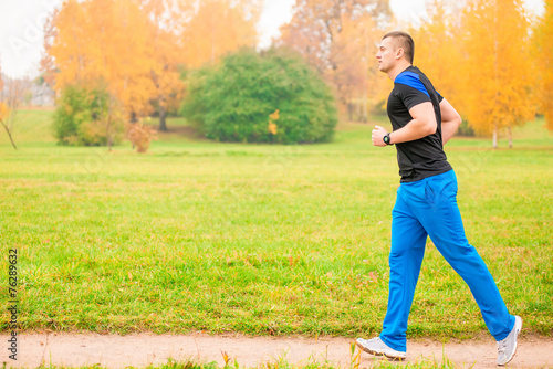 Male athlete jogging in the morning in the park