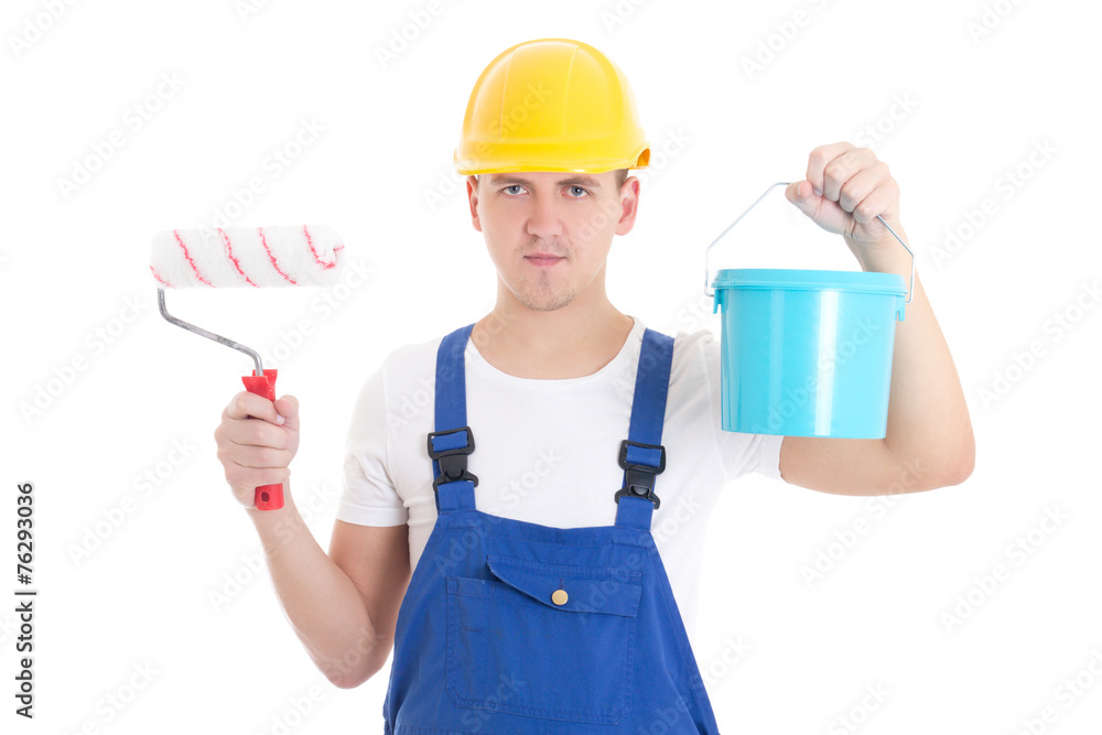 young man painter in blue coveralls with paint brush and bucket young man painter in blue coveralls with paint brush and bucket