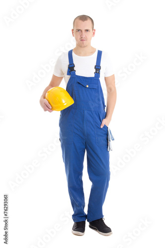 young handsome man builder in blue uniform holding helmet isolat