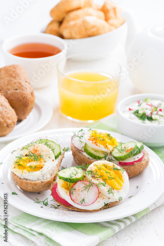 buns with egg and vegetables for breakfast, vertical