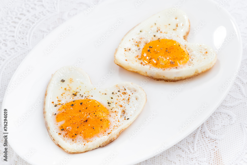 Fried eggs in the form of heart on white plate Fried eggs in the form of heart on white plate