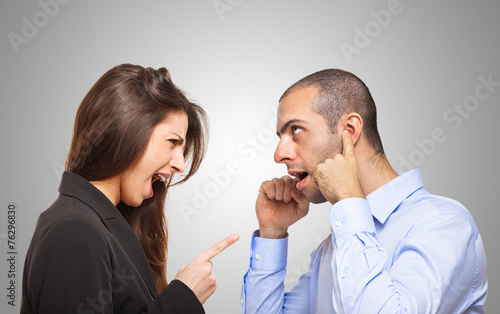 Man covering his ears in front of a woman photo